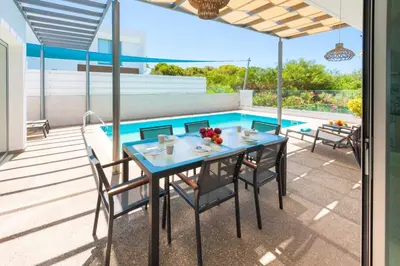 a patio with a table and chairs next to a pool at Elite Panoramic View 3Bdr Villa with pool Ayia Napa in Ayia Napa