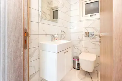 a white bathroom with a sink and a toilet at Royal Panoramic View 3Bdr Villa with pool Ayia Napa in Ayia Napa