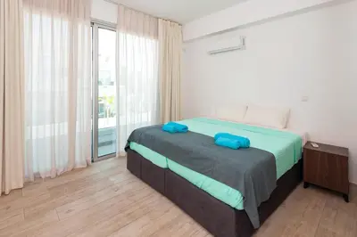 a bedroom with a bed with blue pillows on it at Royal Panoramic View 3Bdr Villa with pool Ayia Napa in Ayia Napa