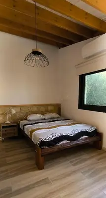 a bedroom with a bed and a chandelier at The Zephyr House in Pyrgos