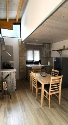 a kitchen with a wooden table and chairs at The Zephyr House in Pyrgos