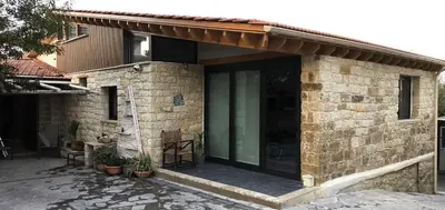 a stone house with a green door and a patio at The Zephyr House in Pyrgos