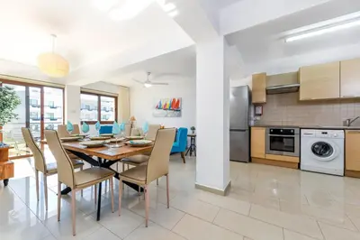 a dining room and kitchen with a table and chairs at Nissi Apartment #102 in Ayia Napa