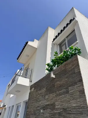 a white house with a window and a brick wall at Dhekelia Beach house - Pyla, Larnaca in Pyla