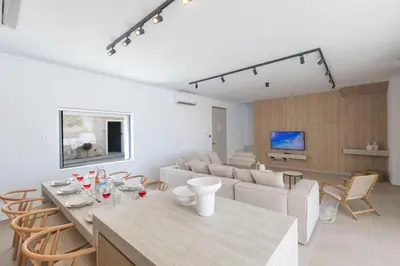 a white living room with a table and chairs at Ayia Napa Orea Villa OR9 in Ayia Napa