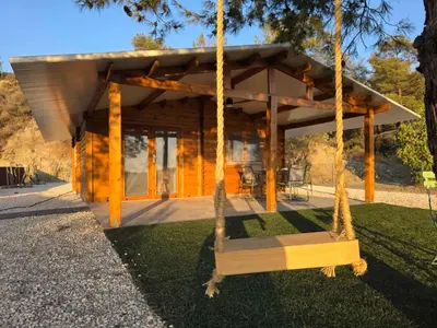a swing in front of a log cabin at Kellaki Relaxation Cottage in Kellaki