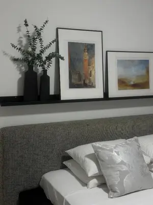 a shelf above a bed with three pictures on it at Modern City Apartment in Larnaka