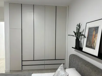 a living room with white cabinets and a couch at Modern City Apartment in Larnaka