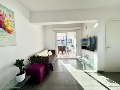 a living room with a purple couch and a tv at STAY Capari Light Apartment in Protaras