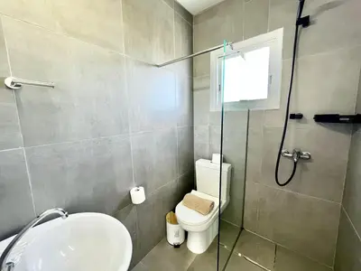 a bathroom with a shower and a toilet and a sink at STAY Capari Light Apartment in Protaras