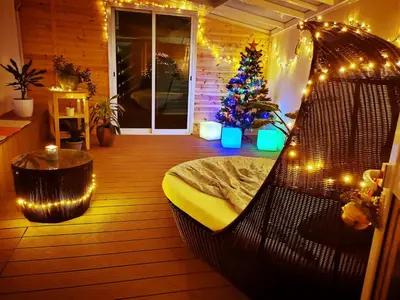 a hammock in a room with a christmas tree and lights at Nestia Apartment in Yermasoyia
