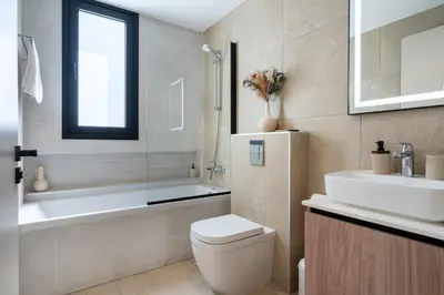 a bathroom with a toilet and a tub and a sink at Densho 2-Bedroom Luxury Apartment in Larnaka