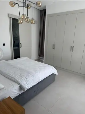 a bedroom with a bed and white cabinets and a chandelier at Mykonos Homes Villa in Aglantzia