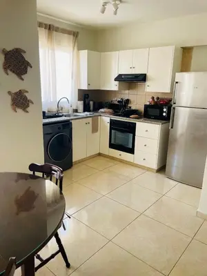 a kitchen with a stainless steel refrigerator and a table at Stay in Harmony in Paralimni