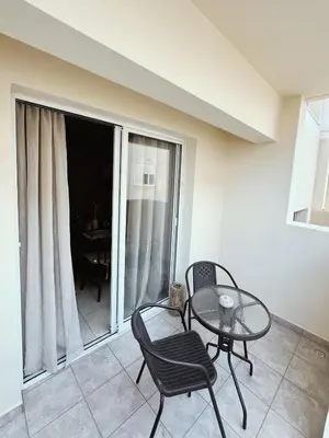 a living room with a table and chairs and a balcony at Stay in Harmony in Paralimni