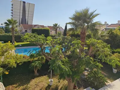 a swimming pool with palm trees and a building at Brand new sea view walking distance to the sea 200m in Limassol