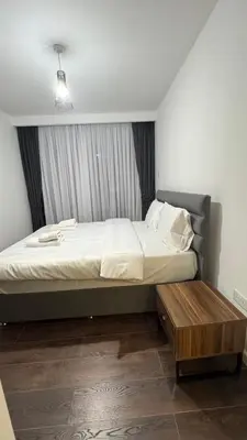 a bedroom with a bed and a wooden table at Long Beach, İskele, Grand Sapphire Resort - Pool View Luxury Studio in Paralimni