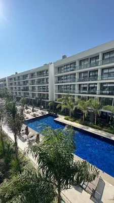 an apartment building with a swimming pool in front of a building at Long Beach, İskele, Grand Sapphire Resort - Pool View Luxury Studio in Paralimni