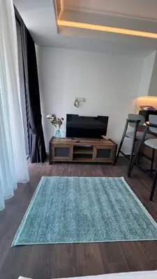 a living room with a television and a rug at Long Beach, İskele, Grand Sapphire Resort - Pool View Luxury Studio in Paralimni