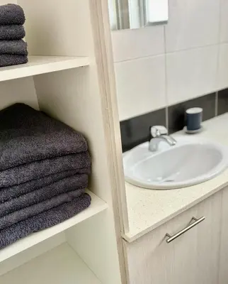 a bathroom with a sink and a mirror and towels at Mariam Court 302 in Larnaka