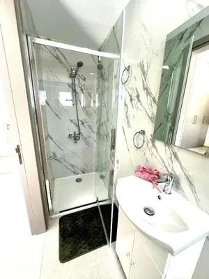 a white bathroom with a shower and a sink at Home in the Hills in Limassol