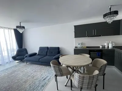 a living room with a table and a blue couch at Penthouse Blueberry North Cyprus in Kérynia