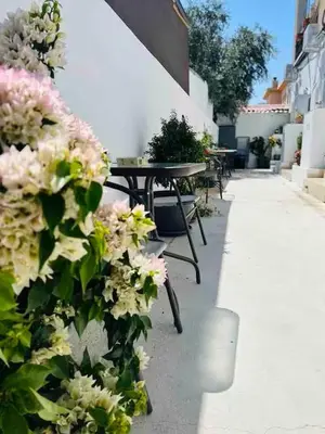 a group of tables and flowers on the side of a building at Сozy and traditional - EC Studios in Larnaka