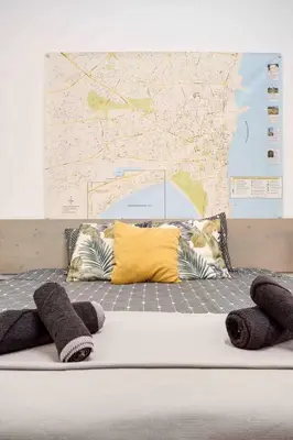 a bed with pillows and a map on the wall at Сozy and traditional - EC Studios in Larnaka
