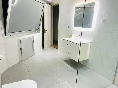 a bathroom with a toilet and a sink and a shower at Plateia suite Grigio in Nicosia