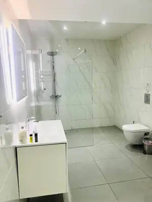 a white bathroom with a shower and a toilet at Plateia suite Grigio in Nicosia