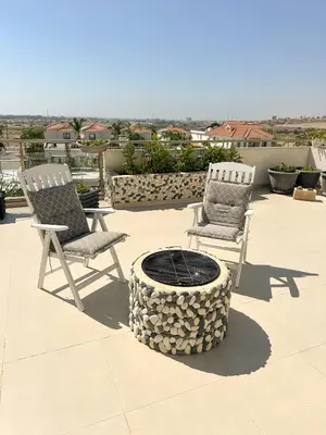 two chairs and a fire pit on a patio at Modern Penthouse Overlooking Pool in Pyla