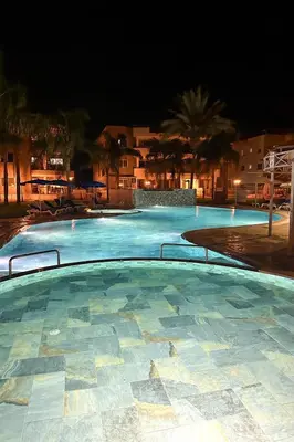 a large swimming pool at night with at Modern Penthouse Overlooking Pool in Pyla