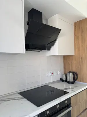 a kitchen with a stove and a black hood at Modern Seaside Studio at Northern Cyprus - Pearl Island in Pyla