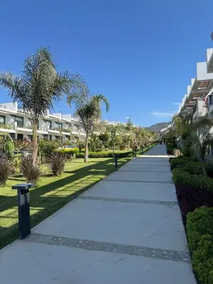 a sidewalk with palm trees and a building at Modern Seaside Studio at Northern Cyprus - Pearl Island in Pyla