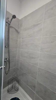 a shower in a bathroom with a tile wall at STAY ZEA Studio in Ayia Napa