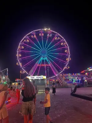 a woman and a child standing in front of a ferris wheel at Grand Sapphire 22 floor B BLock 377, Cypr Północny in Paralimni