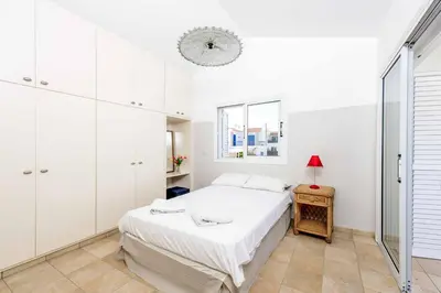 a white bedroom with a bed and a window at Villa Marilena in Protaras