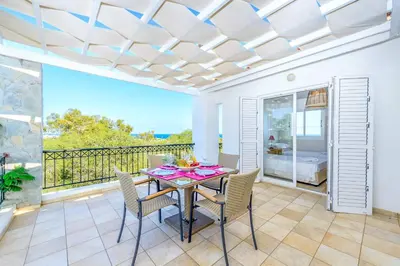 a dining room with a table and chairs on a balcony at Villa Marilena in Protaras