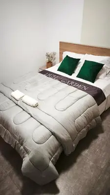 a large white bed with green pillows on it at Light garden in Limassol