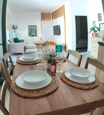 a wooden table with plates and wine glasses on it at Light garden in Limassol