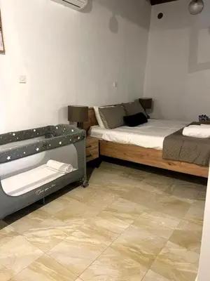 a bedroom with two beds and a tiled floor at The Mansion By Penelope in Omodos