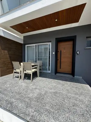 a patio with a table and chairs and a wooden door at Apartman Severny Cyprus in Iskele