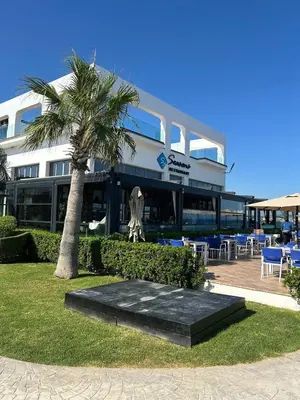 a building with a palm tree in front of it at Apartman Severny Cyprus in Iskele