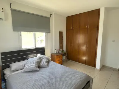a bedroom with a bed and a wooden cabinet at Sunflower Oroklini in Voroklini
