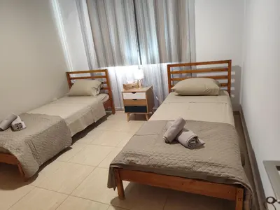 a room with two beds and a table with a night stand at Julia Holiday Apartment in Larnaka