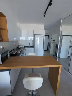 a kitchen with a wooden table and two stools at Caesar Blue Studio Sea View Apartment in Boğaz