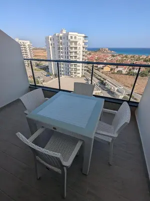 a table and chairs on a balcony with the ocean at Caesar Blue Studio Sea View Apartment in Boğaz