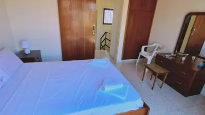a bedroom with a blue bed and a wooden dresser at STAY Sea Gem Apartment in Meneou
