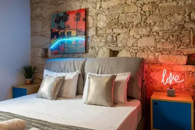 a bedroom with a bed and a brick wall at Exquisite 2BR modern village house w private pool in Ayios Tykhonas