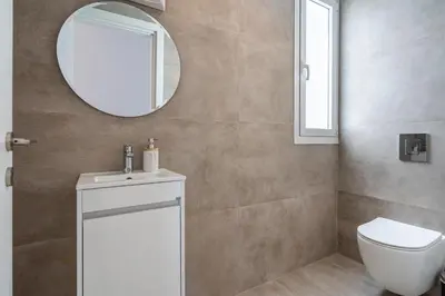 a bathroom with a toilet and a mirror at Blu Horizon - Stylish Living with Pool & Balconies in Protaras in Paralimni